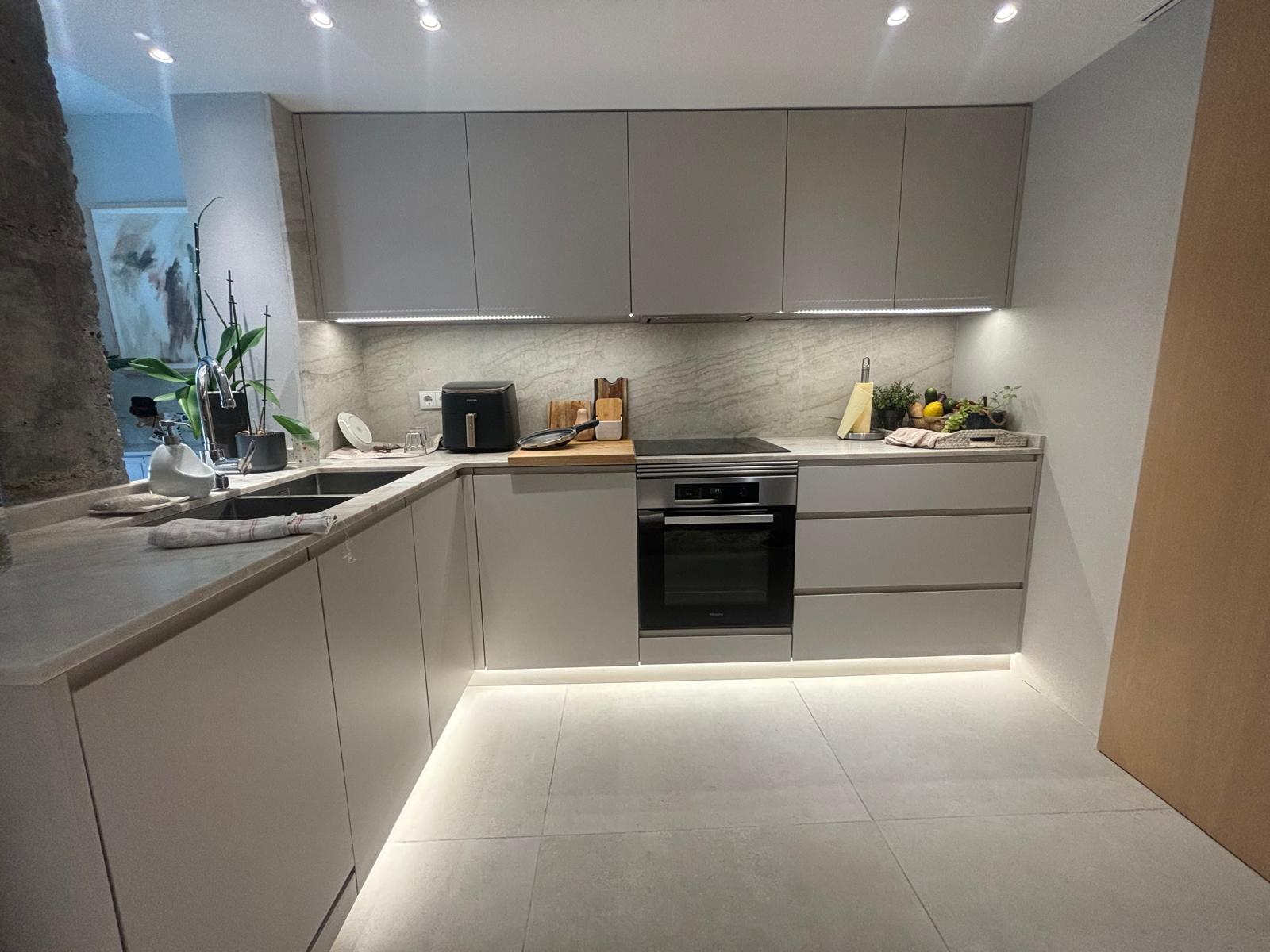 Cocina en U en gris arena con encimera de piedra e iluminación LED